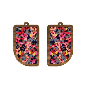 Könnte beinhalten: Ein Paar Holzohrringe mit einem Blumenmuster. Die Ohrringe sind rechteckig mit abgerundeten Ecken und haben ein kleines Loch oben zum Aufhängen.