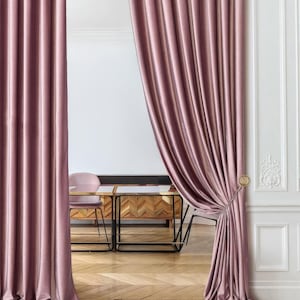 Double-sided luxe velvet divider curtains in warm taupe-brown tones, hung on black curved metal rod. Elegant room divider drapes with rope tiebacks and tassels, featuring sophisticated pleats and full floor-length drape. Customizable luxury curtain panels ideal for archway entrances, bedroom partition, or creating separate room spaces. High-end interior design window treatment with rich velvet texture. Professional home decor solution for modern and classical interiors.