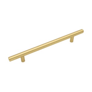 May include: A brushed gold cabinet pull with a cylindrical shape and rounded edges.