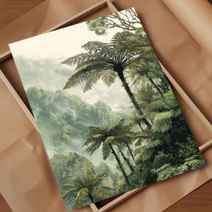 May include: A framed art print featuring a lush, green landscape with tall ferns and a misty mountain backdrop. The artwork has a vintage aesthetic, with soft colors and a focus on natural elements. The print is set in a light-colored wooden frame.
