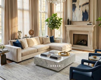 May include: A luxurious living room featuring a large beige sectional sofa with navy blue accent pillows. A marble coffee table with books sits on a patterned rug. The room includes a fireplace, artwork, and a crystal chandelier.