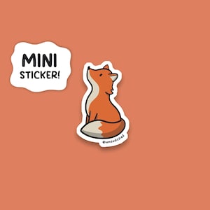 May include: A mini sticker featuring a cartoon fox with orange and white fur, sitting upright with its head tilted back. The sticker is on a solid orange background. A white speech bubble with the words "MINI STICKER!" is to the left of the fox.