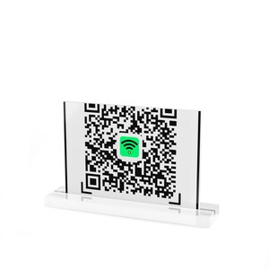 May include: A rectangular clear acrylic sign holder featuring a printed white card with a large black QR code and a central green square icon containing a black Wi-Fi symbol and a small yellow star, all supported by a clear acrylic base.