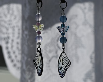 May include: Two butterfly charm keychains with blue and purple beads, and a clear butterfly charm with a silver outline.