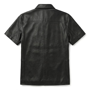 Puede incluir: Camisa negra de cuero de manga corta con cuello cl&aacute;sico. La camisa tiene una botonadura frontal y un corte entallado. La parte trasera de la camisa tiene un canes&uacute; y costuras verticales. Una prenda elegante y vers&aacute;til.