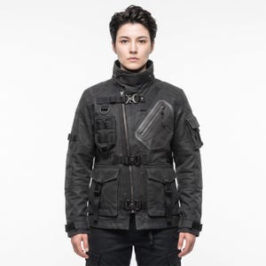 May include: A black tactical jacket featuring a high collar, an asymmetrical front zipper, and multiple utility pockets. The garment includes adjustable straps with plastic buckles, D-rings, and reinforced panels on the sleeves and chest area.