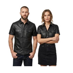 Puede incluir: Camisas de cuero negro de manga corta con dos bolsillos en el pecho. Las camisas tienen una parte delantera abotonada y se usan con vaqueros oscuros y una falda vaquera negra. Las camisas son usadas por dos personas.
