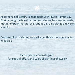 Op de afbeelding: Tekst op een lichtblauwe achtergrond: "Alle Jasmine Sol Jewelry is handgemaakt met liefde in Tampa Bay, Florida, met behulp van de mooiste natuurlijke edelstenen, zoetwaterparels, parelmoer, natuurlijke schelp en 18-24k vergulde en vermeil accenten."