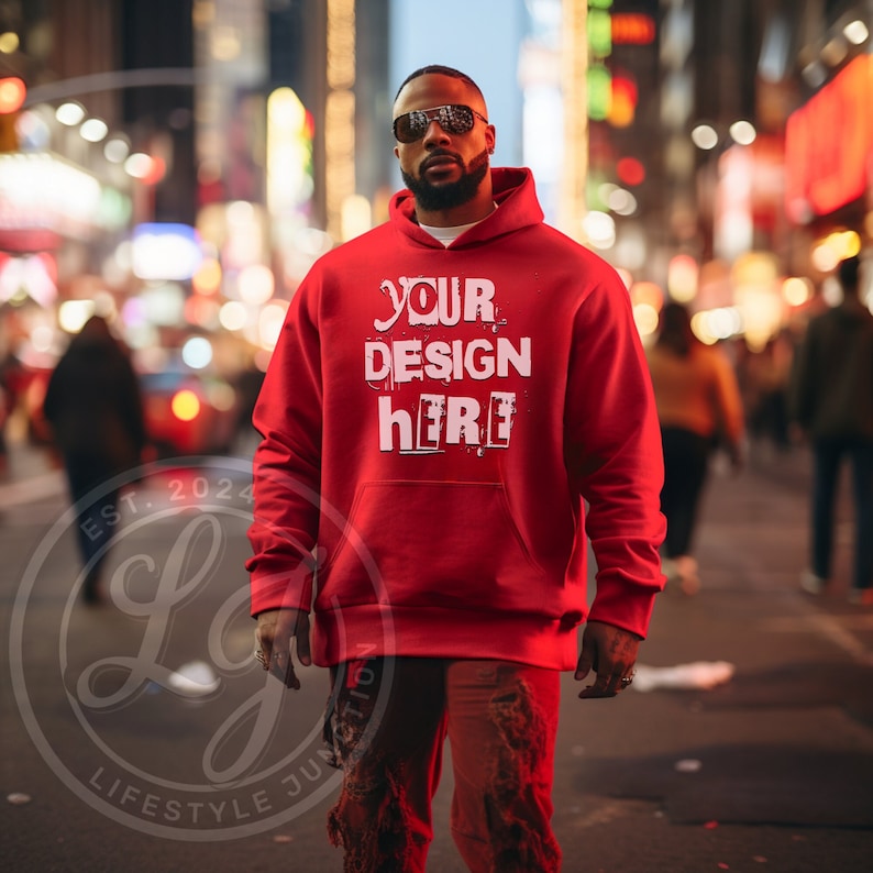 May include: A red hoodie with the text "YOUR DESIGN HERE" in white. The hoodie has a front pocket and a drawstring hood. The person in the image is wearing sunglasses and standing in a city street.
