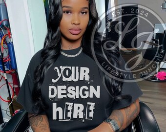 May include: A black t-shirt with the text "YOUR DESIGN HERE" in white, printed in a distressed style. The shirt is being modeled by a person with long black hair.