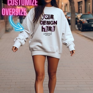 Pode incluir: Uma camiseta branca oversized com o texto "YOUR DESIGN here" em letras rosa e pretas. O texto "LIFESTYLE JUNCTION" &eacute; impresso em preto abaixo do design.