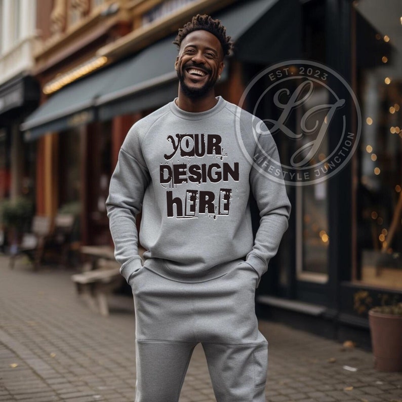 May include: A grey sweatshirt with the text "YOUR DESIGN HERE" in black. The sweatshirt is part of a matching tracksuit. The model is wearing the sweatshirt and matching sweatpants.
