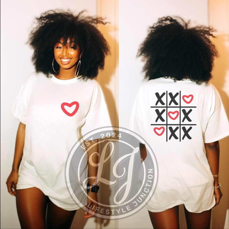 Peut inclure: T-shirt blanc surdimensionn&eacute; avec un c&oelig;ur rouge sur le devant et un c&oelig;ur rouge et des X noirs en forme de tic-tac-toe au dos. Le t-shirt porte le texte "EST. 2024 LJ LIFESTYLE JUNCTION" en bas &agrave; gauche.