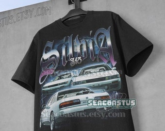 May include: Black t-shirt with a graphic print of three white Nissan Silvias. The graphic includes the text "Silvia S13" and the website "seacoastus.etsy.com".