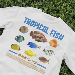 May include: White t-shirt with a graphic of colorful tropical fish and the text "Tropical Fish". The text "無糖無Tシャツ" is also printed on the shirt.