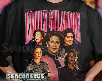 May include: Black t-shirt with a graphic print of four women. The graphic features the text "Emily Gilmore" in pink and red letters. The women are wearing different outfits and have different hairstyles. The t-shirt is a relaxed fit and has a crew neck.