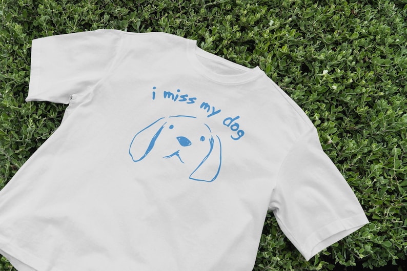 May include: White t-shirt with a blue graphic of a dog and the text "i miss my dog"