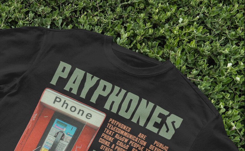 May include: Black t-shirt with the word "PAYPHONES" in green, and a graphic of a red payphone booth. The word "Phone" is also visible. The shirt has a vintage, retro aesthetic.