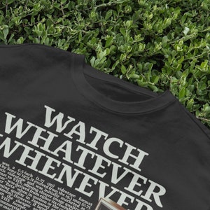 May include: Black t-shirt with white text that reads "WATCH WHATEVER WHENEVER".