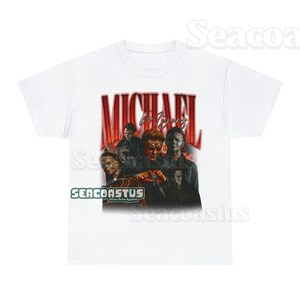 May include: White t-shirt with a vintage-style graphic of Michael Myers from the Halloween franchise. The graphic features multiple images of Michael Myers in different poses, with the text "MICHAEL MYERS" in red and black letters.