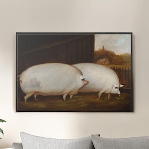 Könnte beinhalten: Gerahmtes Kunstwerk mit zwei großen weißen Schweinen in einer ländlichen Umgebung. Die Schweine sind der Mittelpunkt, vor dem Hintergrund einer Holzkonstruktion und einem Blick auf eine ländliche Landschaft. Das Kunstwerk ist schwarz gerahmt.