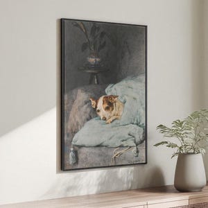 Puede incluir: Impresión enmarcada que muestra un perro acurrucado en una manta azul claro sobre un sofá. El perro tiene marcas marrones y blancas. La obra de arte tiene una estética vintage, con un fondo oscuro y una planta en un jarrón.