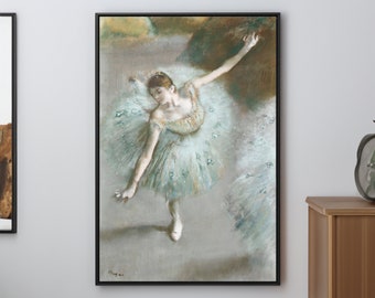 Può includere: Stampa incorniciata di una ballerina di balletto in tutù azzurro, con le braccia graziosamente estese. L'opera d'arte, dai toni pastello tenui, è ambientata su uno sfondo neutro. La cornice nera valorizza l'opera, aggiungendo un tocco di eleganza all'arredamento.
