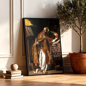 May include: A framed print of a classical painting depicting a bearded figure in ornate gold and white robes, holding a quill and a flaming heart. The figure sits at a desk with open books, surrounded by dark shadows and a bright light source above.