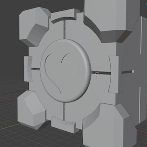 Könnte beinhalten: Ein graues, würfelförmiges Objekt mit einem Herzdesign auf der Vorderseite. Der Würfel hat ein kreisförmiges Emblem mit einem Herz in der Mitte, umgeben von kreuzförmigen Akzenten. Die Ecken und Seiten haben geometrische Formen.