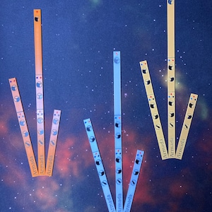 May include: A set of six Armada game pieces, each with a different color scheme. The pieces are made of cardboard and have a rectangular shape. The pieces are arranged in a vertical line, with the top piece being the tallest. The pieces are all labeled with the word "Armada".