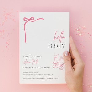 May include: A white invitation card with pink accents and the text "hello FORTY." The card features a pink bow design and illustrations of champagne glasses. The invitation is for Aria Belle's birthday celebration.