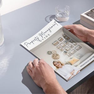 K&ouml;nnte beinhalten: Ein wei&szlig;-schwarzes Magazin mit dem Titel "Property Management Guide" auf dem Cover. Das Magazin ist auf einer Seite ge&ouml;ffnet, die ein Foto einer Frau in einem wei&szlig;en Hemd und einen Raum mit vielen gerahmten Bildern an der Wand zeigt. Der Text "Presented by Amy Brooks" befindet sich am unteren Rand der Seite.