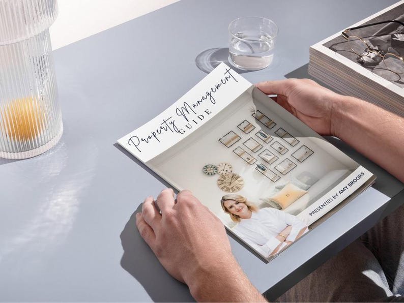 K&ouml;nnte beinhalten: Ein wei&szlig;-schwarzes Magazin mit dem Titel "Property Management Guide" auf dem Cover. Das Magazin ist auf einer Seite ge&ouml;ffnet, die ein Foto einer Frau in einem wei&szlig;en Hemd und einen Raum mit vielen gerahmten Bildern an der Wand zeigt. Der Text "Presented by Amy Brooks" befindet sich am unteren Rand der Seite.