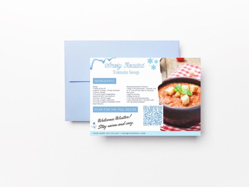 Pode incluir: Um cart&atilde;o de receita para Sopa de Tomate Assada Defumada com um c&oacute;digo QR para escanear para obter a receita completa. O cart&atilde;o tem um design azul e branco com flocos de neve e uma tigela de sopa de tomate com torradas e manjeric&atilde;o por cima.