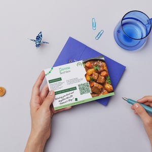 Pode incluir: Um cart&atilde;o de receita verde e branco com uma imagem de ensopado de carne Guinness. O cart&atilde;o tem o t&iacute;tulo "Guinness Beef Stew" e inclui um c&oacute;digo QR. O cart&atilde;o est&aacute; sobre um envelope azul com fundo branco.