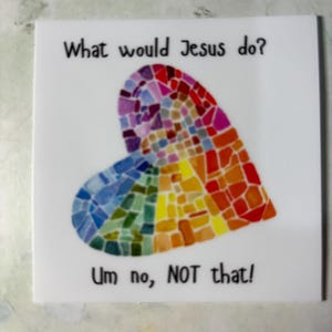 Pode incluir: Azulejo quadrado branco com o texto "What would Jesus do?" acima de um coração de mosaico colorido. Abaixo do coração, o texto diz "Um no, NOT that!" O design do coração apresenta um arco-íris.