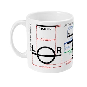 Pode incluir: Caneca de cerâmica branca com um diagrama preto e vermelho, incluindo o texto "DECK LINE", "L O R" e medidas em milímetros. A caneca também tem o texto "Assigned summer freeboard".
