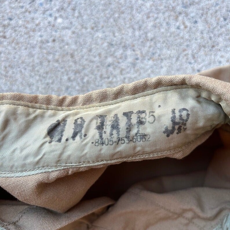 May include: Close-up of a tan fabric with the text "U.S. ARMY" and "5" printed on it.