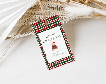 Peut inclure: Une étiquette cadeau de Noël avec une bordure à carreaux rouges et verts. L'étiquette présente les mots "JOYEUX NOËL" et une illustration d'ours en peluche portant un pull et un chapeau de fête. Le texte "AVEC AMOUR, LES WILSONS" est également inclus.