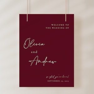 Könnte beinhalten: Ein burgunderfarbenes Willkommens-Schild mit weißem Text, der lautet: "Willkommen zur Hochzeit von Olivia und Andrew, wir freuen uns, dass Sie da sind! 23. September 2023".
