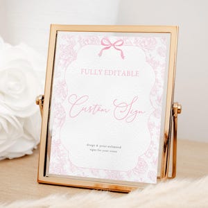 May include: A gold-framed sign with a pink floral design and a pink ribbon. The sign says "FULLY EDITABLE Custom Sign design & print unlimited signs for your event".