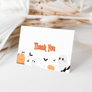May include: A white thank you card with the text "Thank You" in orange. The card is decorated with cartoon ghosts, bats, and a pumpkin.