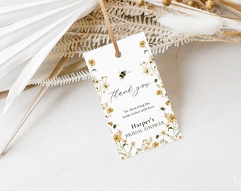 May include: A white thank you tag with a floral design and bees. The text reads "Thank you for showering the bride to bee with love Harper's Bridal Shower".