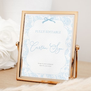 May include: A gold-framed sign with a blue floral border and a white background. The sign says "FULLY EDITABLE Custom Sign design & print unlimited signs for your events".