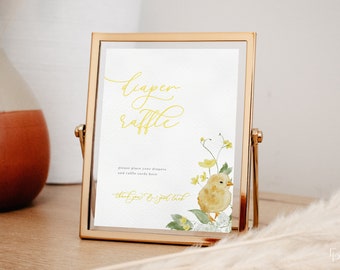 May include: A gold-framed sign with a white background and yellow text that reads "Diaper Raffle". The sign also includes a watercolor illustration of a yellow chick with green leaves and yellow flowers.