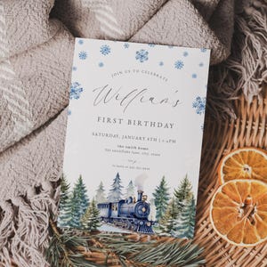 May include: A birthday invitation with a watercolor illustration of a blue train and evergreen trees. The invitation has the text "Join us to celebrate William's First Birthday" and the date and time.