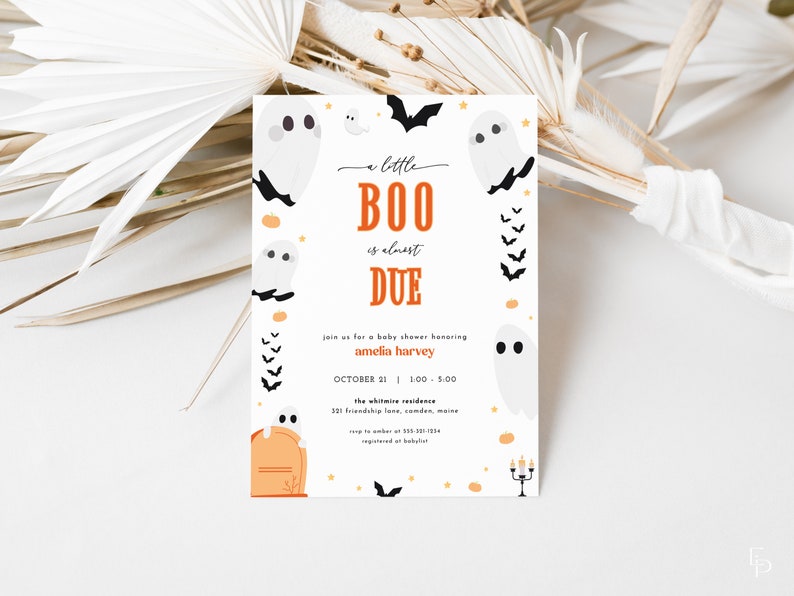 May include: A white card with a Halloween baby shower invitation. The card features a ghost with the text "a little BOO is almost DUE". The invitation is decorated with orange and black bats and pumpkins.