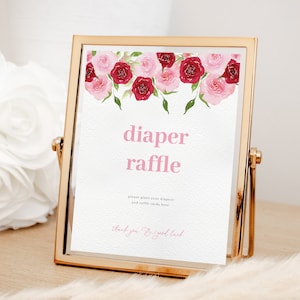 Puede incluir: Un cartel con marco dorado con un diseño floral rosa y rojo. El cartel dice "rifa de pañales" e incluye el texto "Por favor, coloque sus pañales y las tarjetas de la rifa aquí. Gracias y buena suerte".