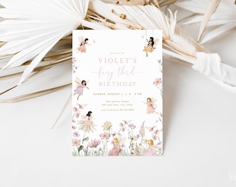 May include: A light pink invitation for Violet's third birthday, featuring a fairy theme. The invitation includes illustrations of fairies, flowers, and the text "fairy third birthday". The invitation is surrounded by dried flowers and palm leaves.