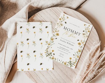 Puede incluir: Una invitación a una fiesta de bienvenida al bebé con una corona de flores y abejas. El texto dice "Let's shower the Mommy to be. Join us for a baby shower to celebrate Scarlett Williams. Sunday, June 24th | 1-4PM. The Hampshire Hotel, 223 Hampshire Lane, City, State. RSVP to [phone number] by [date]."